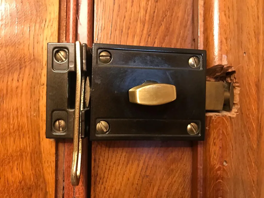 Cerrojo de sobreponer montado en una puerta de madera