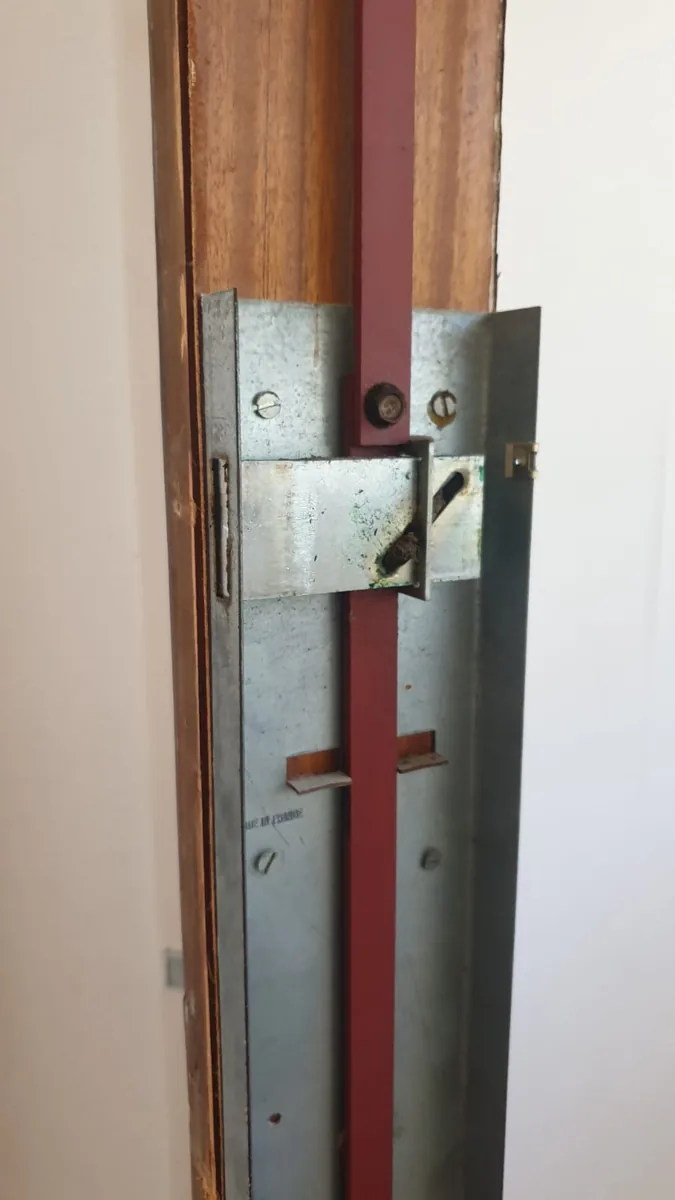 Cerradura vista en el canto de la puerta, con los bulones fuera